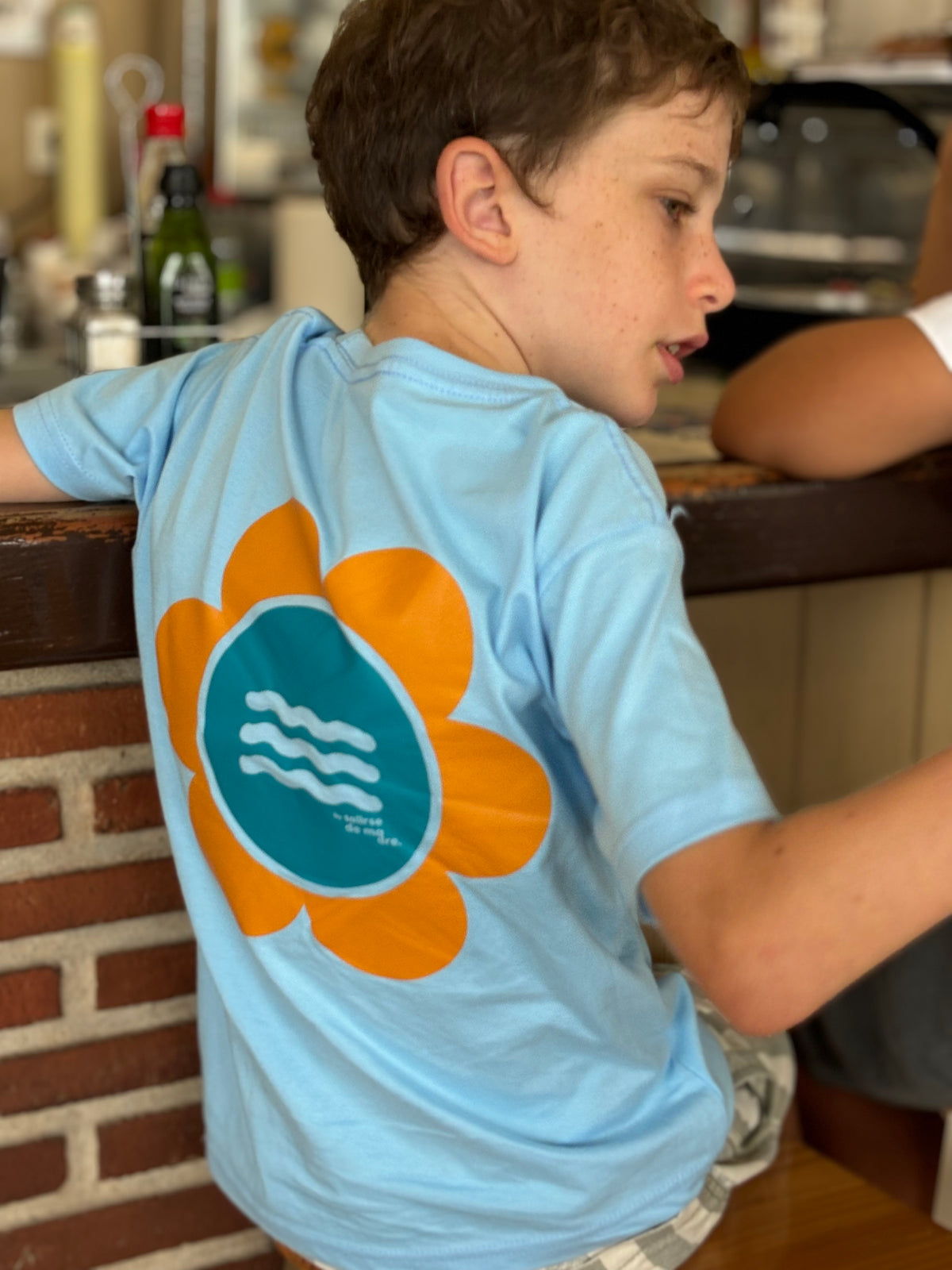 CAMISETA CELESTE "SO MUCH FLOWERS" NARANJA AND BLUE GREEN